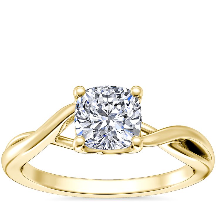 a yellow gold engagement ring with a cushion cut diamond in the center and twisted band