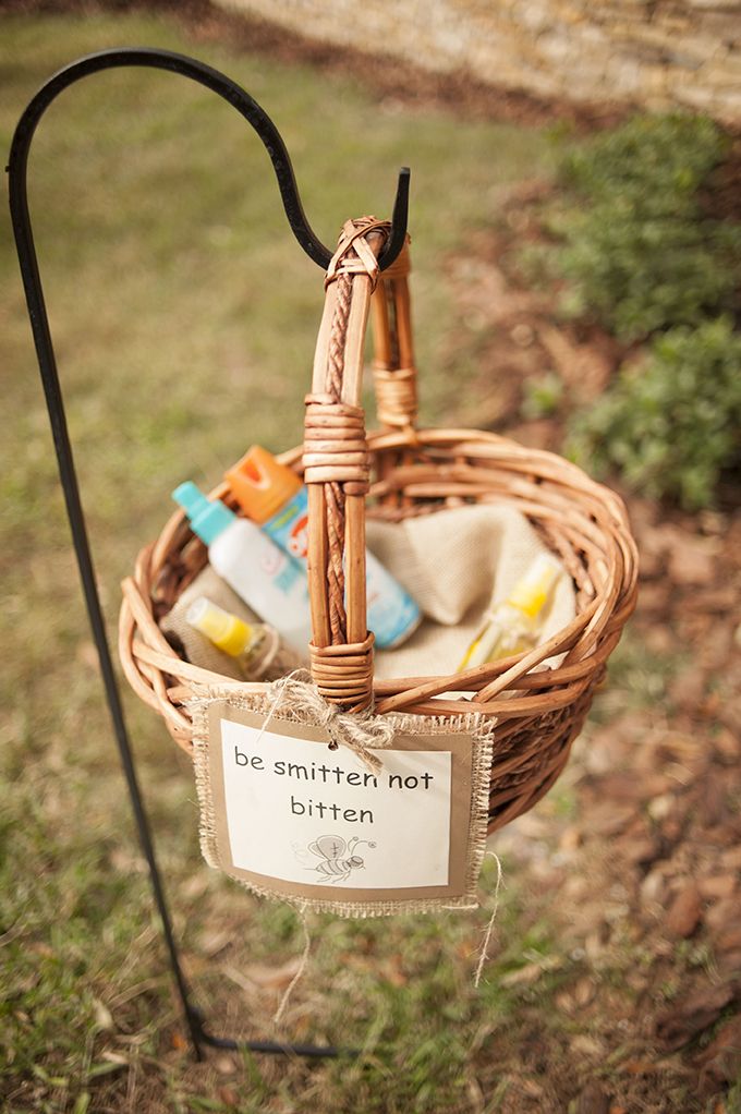 a basket filled with baby items sitting on top of a grass covered field