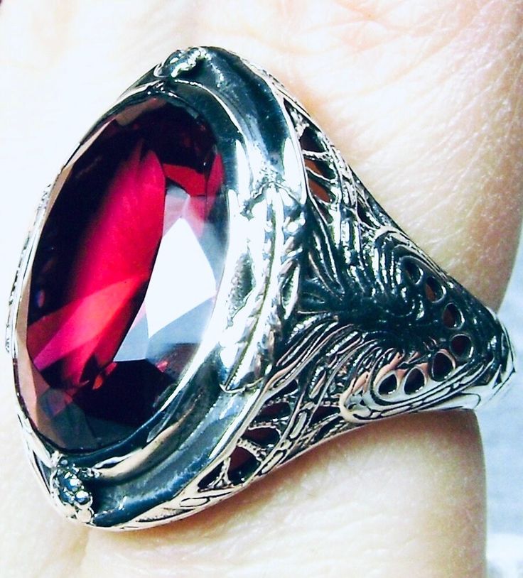 Simulated Red Ruby Ring GG Design#2 Custom Made Inspired by Victorian era designs, we have this lovely Antique filigree reproduction ring in sterling silver. There is 4 filigree flowers around the edge of the ring, notice the filigree which extends down the band. This well made setting is sterling silver and is marked 925. This is an eye popping, stunning, bezel set 16ct Simulated red ruby gemstone. This gorgeous gemstone is 17mm x 13mm in dimensions; just shy of 3/4th of an inch long by 1/2 inc Classic Red Ruby Ring, Oval Cabochon, Classic Red Ruby Ring With Oval Cabochon, Heirloom Red Signet Ring With Polished Finish, Classic Red Oval Cabochon Signet Ring, Vintage Red Signet Ring With Oval Cabochon, Vintage Red Oval Cabochon Signet Ring, Red Oval Cabochon Signet Ring For Formal Occasions, Red Oval Cabochon Jewelry With Polished Finish, Vintage Red Hallmarked Signet Ring