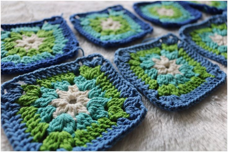 four crocheted squares are arranged on a table