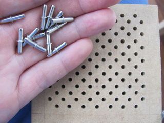 a person holding several small screws in their hand