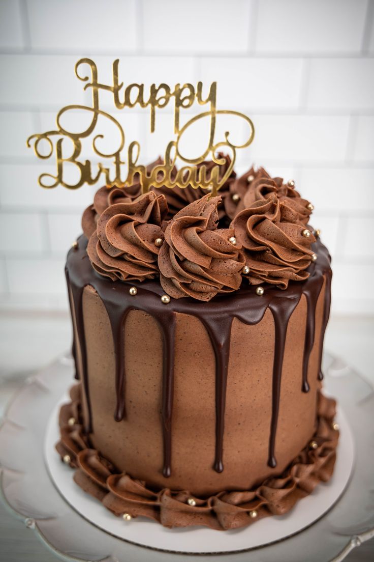 a birthday cake with chocolate frosting and a happy birthday sign