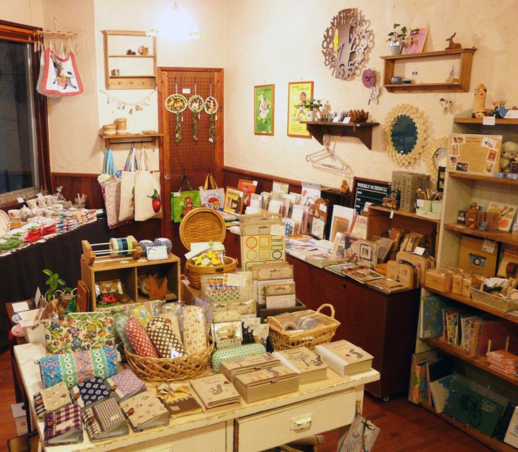 a room filled with lots of boxes and baskets on top of wooden tables next to windows