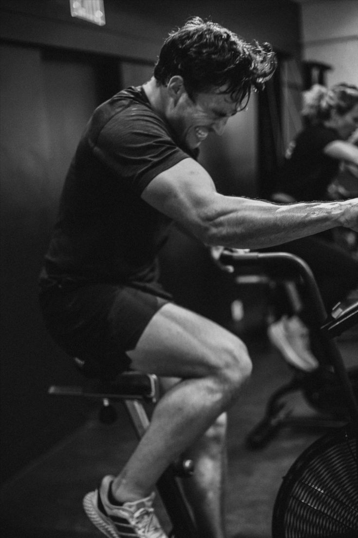 a man is riding an exercise bike in the gym