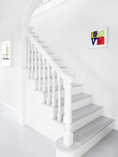 a white staircase leading up to a window in a room with white walls and floors