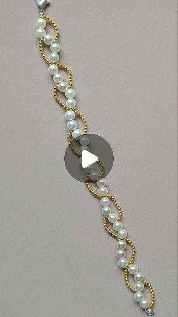 a gold and white bracelet with pearls on it