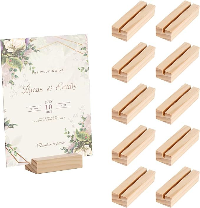 wooden pegs and wedding card holders on white background with floral design in the middle