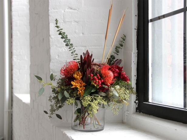 a vase filled with flowers sitting on top of a window sill