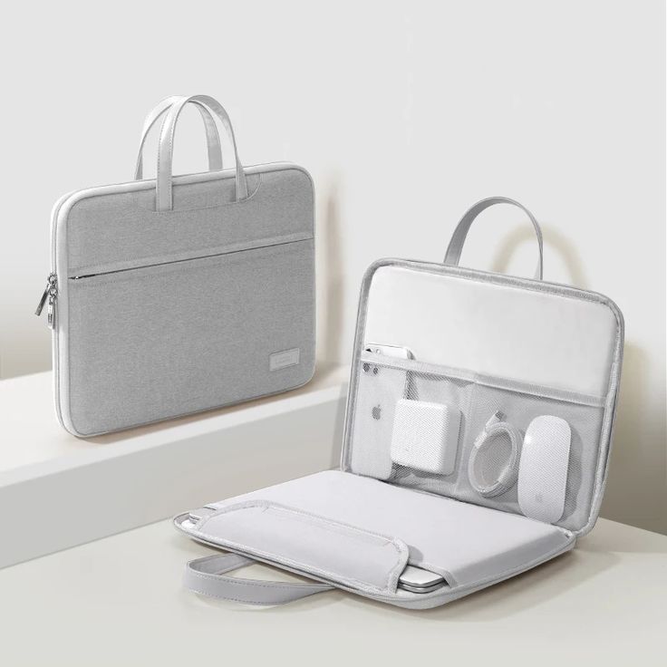 an open laptop bag sitting on top of a white table next to another bag with ear buds