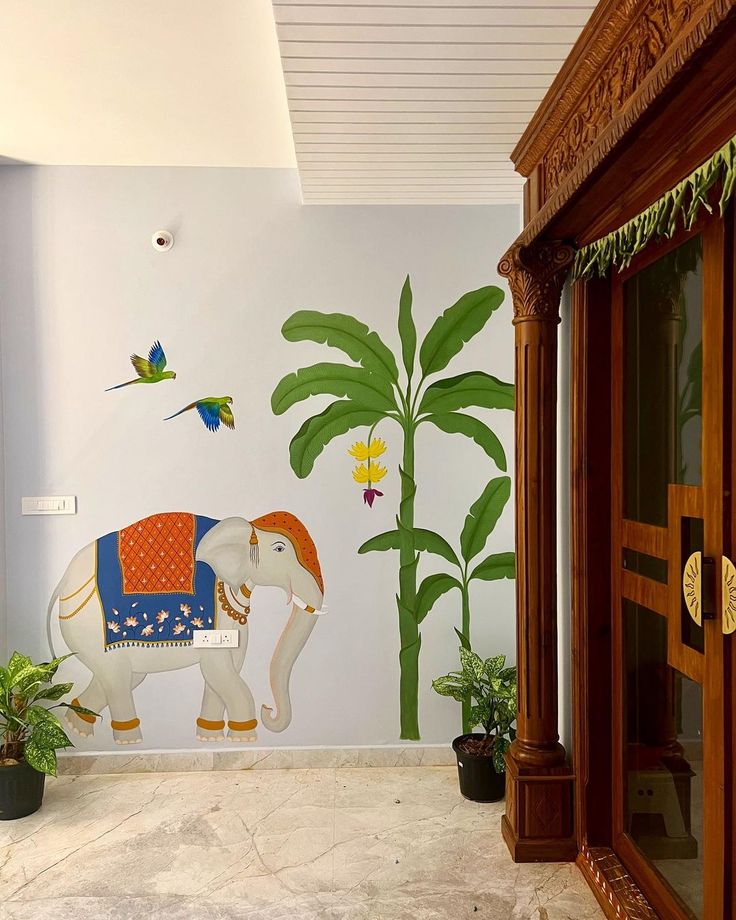 an elephant painted on the side of a wall next to plants and potted plants