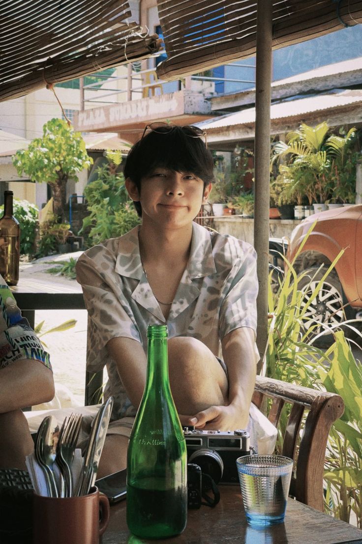 two people sitting at an outdoor table with food and drinks in front of them,