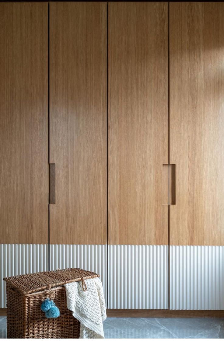 a room with some wooden cabinets and a basket on the floor in front of it