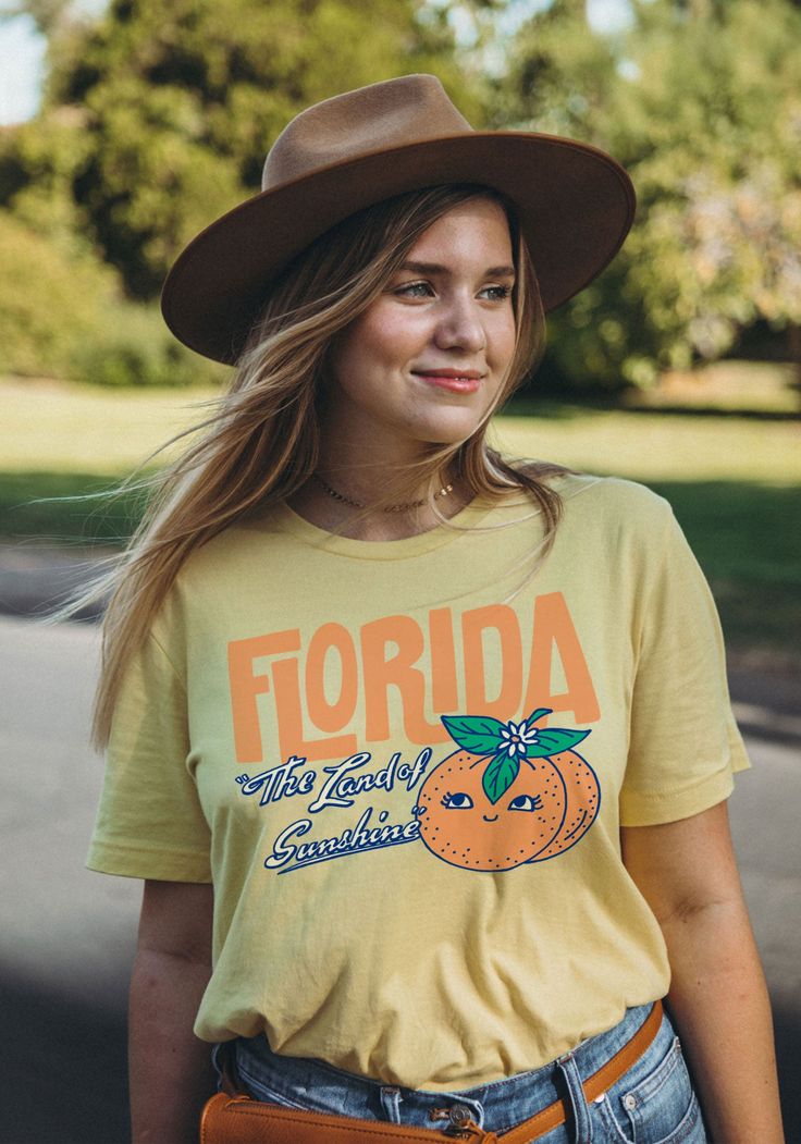 Ahh, nothing like fresh-squeezed sunshine. Breathe in the orange blossoms and beachy air with our new Florida tee. Inspired by vintage postcards and old souvenirs, this Floridian kitsch is sure to make you glow like the sun over the Keys. Unisex crew neck tee in Yellow. 100% combed and ring-spun cotton. Model wears size Large. Yellow T-shirt For Spring Vacation, Orange Relaxed Fit T-shirt For Beach, Orange Crew Neck Summer T-shirt, Orange Short Sleeve Top For Beach Season, Spring Vacation Tops With Screen Print, Orange Letter Print T-shirt For Spring, Yellow Vacation T-shirt For Spring, Yellow Spring Vacation T-shirt, Summer Orange Tops With Graphic Print