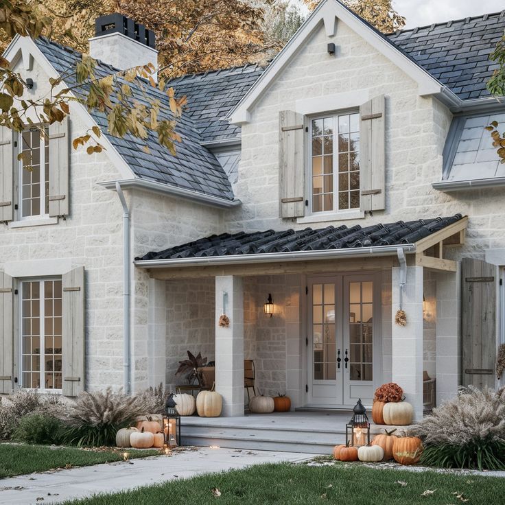 a white house with pumpkins on the front porch