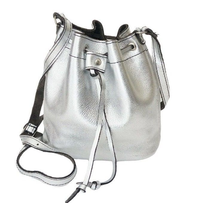 Bucket silver Leather bag Greek leather bag Metalic bucket silver bag Handmade bag Gold leather shoulder bag Crossbody leather bag Greek silver leather bag with one room in main body - Adjustable leather shoulder or crossbody strap - Real genuine leather - The bag has unlined interior - Leather drawstring closure Dimensions Small Height 19cm/ 7.5 inches Length - 24cm / 9.4inches Width 11cm/ 4 inches Strap 100-120cm / 39-47 inches for more bags please visit this section: https://www.artncreate.co Handmade Fabric Bags, Crossbody Leather Bag, Silver Bag, Silver Bags, Bag Silver, Handmade Bag, Bag Handmade, Fabric Bag, Gold Leather