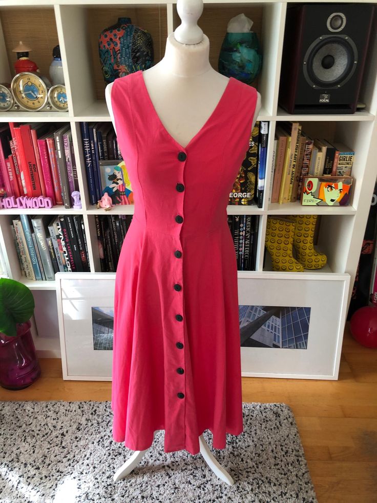 Super fresh little 80s-does-50s sundress giving us serious summer feelings. The bright pink colour and big black buttons are a nod to the 80s but still looks super modern and wearable. A perfect addition to your wardrobe that you can dress up or down.  Great condition, by 'Gayle Glass'. Would best fit a UK size 8 Bust 34' Waist 26' Hips free Length 34' Mannequin's measurements (UK size 10) Bust: 34' Waist: 27' Hips 37' Item pinned on model? No, but it's snug around the waist Please remember all Retro V-neck Dress With Buttons, Retro V-neck Dress With Button Closure, Fitted Retro Midi Dress For Day Out, Retro Fitted Midi Summer Dress, Retro Fitted Midi Dress For Summer, Fitted Retro Midi Dress For Summer, 1950s Style Summer Midi Dress, Retro Dresses With Buttons For Day Out, Pink Buttoned Knee-length Midi Dress