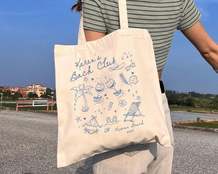 a woman carrying a tote bag with drawings on it