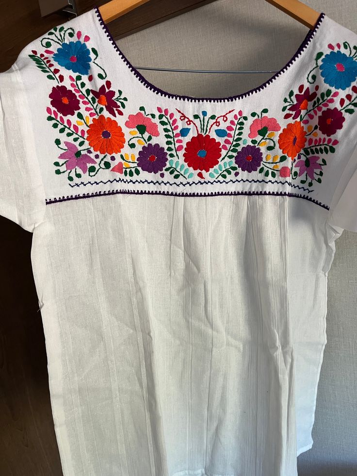 These beautiful blouses feature hand embroidery at the top and on the back. The material is very light and breezy. The portion at the bottom is pleated and flows out in an a-line shape. You may want to wear a tank underneath but I don't find them to be super transparent. Measurements: Armpit to armpit: 20", Length 27.5" The embroidered portion is above the bust so it gives a lot of loose room to fit many bust sizes. Hand made in Mexico Care instructions: Please do not put your top in the washing Summer Crew Neck Blouse With Floral Embroidery, Summer Purple Blouse With Crew Neck, Summer Crew Neck Blouse In Purple, Purple Crew Neck Blouse For Summer, Multicolor Summer Blouse With Embroidered Hem, Multicolor Embroidered Hem Blouse For Summer, Summer Multicolor Blouse With Embroidered Hem, Embroidered Crew Neck Blouse For Summer, Summer Crew Neck Top With Embroidered Neckline