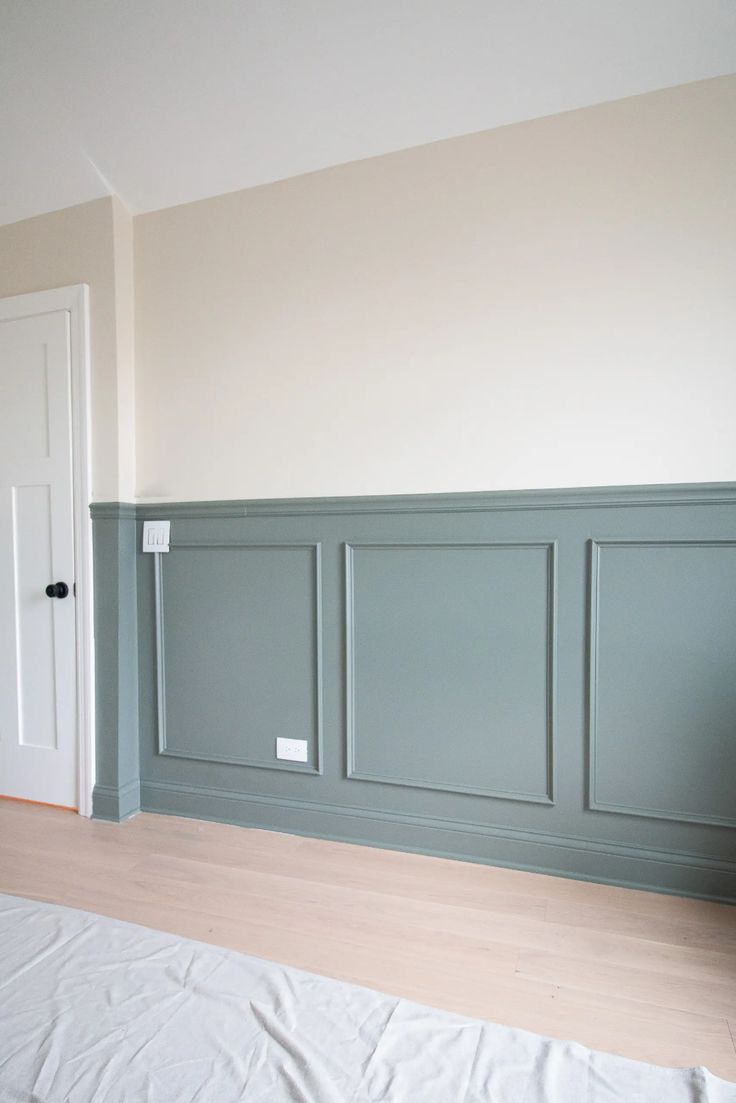 an empty room with wood flooring and walls painted in pale blue, white and beige