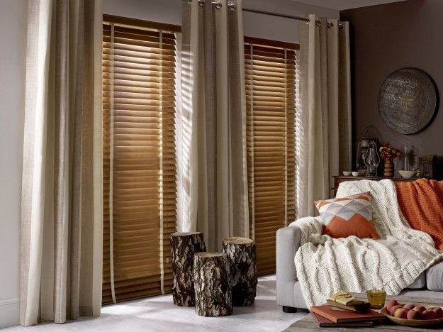 a living room with white furniture and wooden blinds