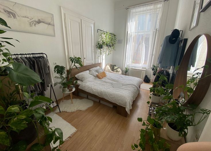 a bed room with a neatly made bed and lots of plants