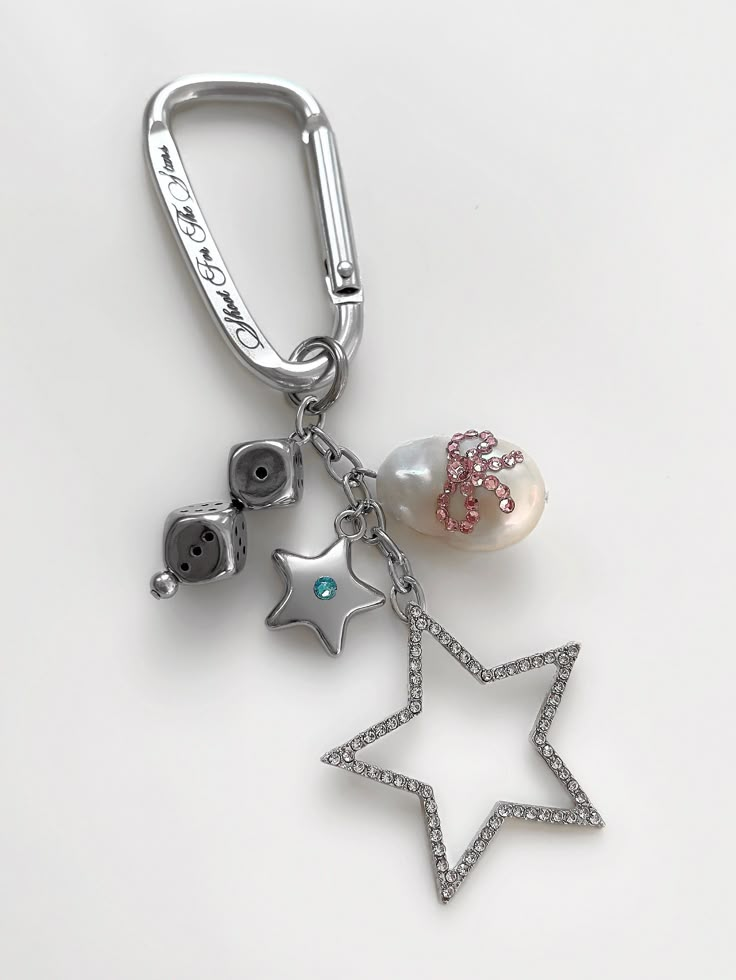 a silver key chain with charms attached to it's ends and star on the end