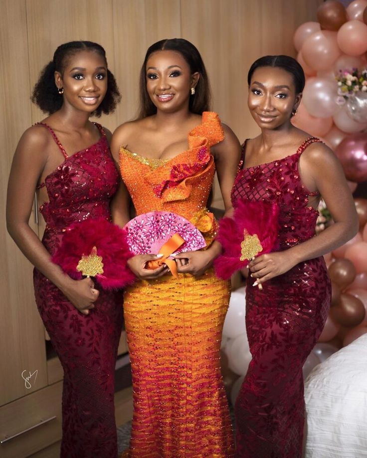 three women standing next to each other in dresses