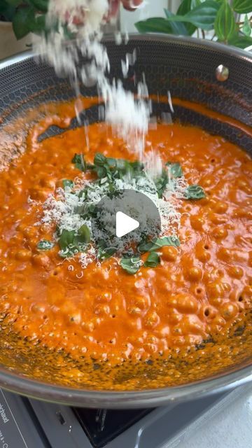 a large pot filled with lots of red sauce on top of a stove burner