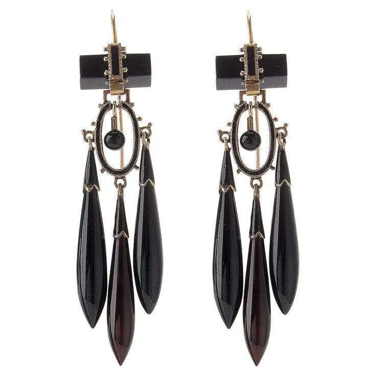 Composed of onyx, enamel and 14K gold, these antique pendant earrings were created around 1870. Each is designed as an onyx bar suspending a cascade of flexibly-set sphere, black enamel oval element and three tapering onyx drops with shaped enamel caps, accented by applied beads. Freely moving and magically lightweight, these fabulous antique earrings are delightfully intricate and beautiful. Product Details: Item #: ER-21022 Circa: 1870 Dimensions: 2.75" length x 0.75" width Materials: Onyx; Black Enamel; 14K Gold Macklowe Gallery Curator's Notes: Earrings and necklaces with elongated torpedo shape drops referenced Etruscan and Greek forms that had been imaginatively enlarged and reinterpreted by French and Italian Archaeological Revival jewelers such as Fontenay and Castellani. Luxury Black Enamel Formal Earrings, Red Priestess, Onyx Bar, Helaena Targaryen, Antique Pendant, White Dragon, Antique Earrings, Ear Jewelry, Black Enamel