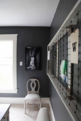 a white chair sitting next to a window in a bathroom under a painting on the wall