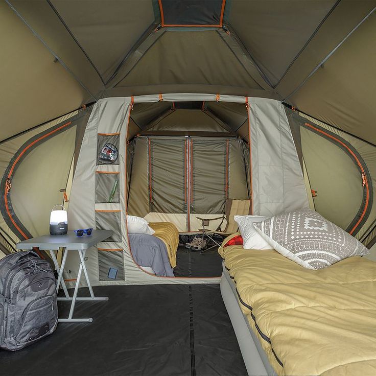 the inside of a tent with two beds