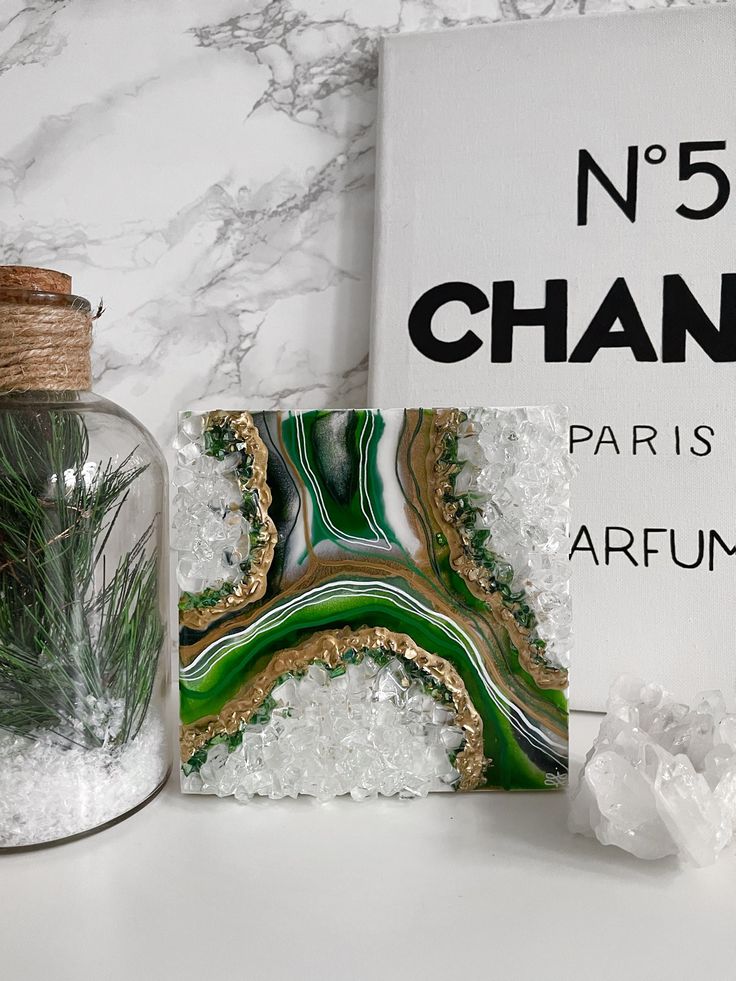 a glass jar filled with green plants next to a sign that says no 5 chandelier