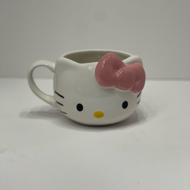 a hello kitty mug with a pink bow on it