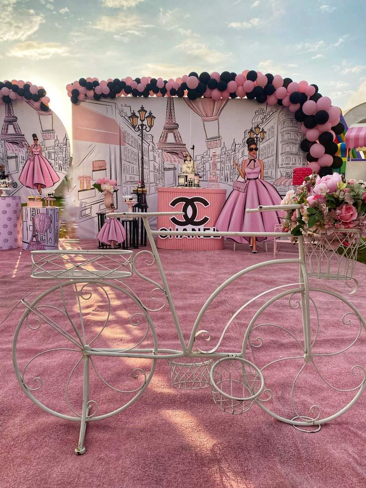 a pink carpeted area with a white bicycle and decorations on the wall behind it