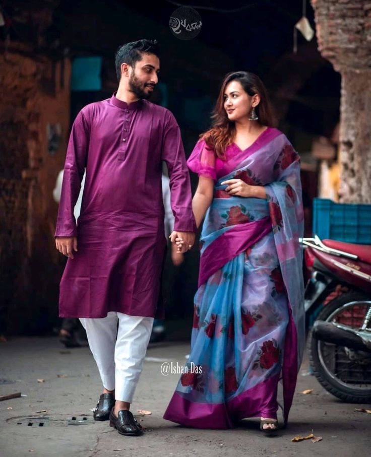 a man and woman walking down the street holding hands