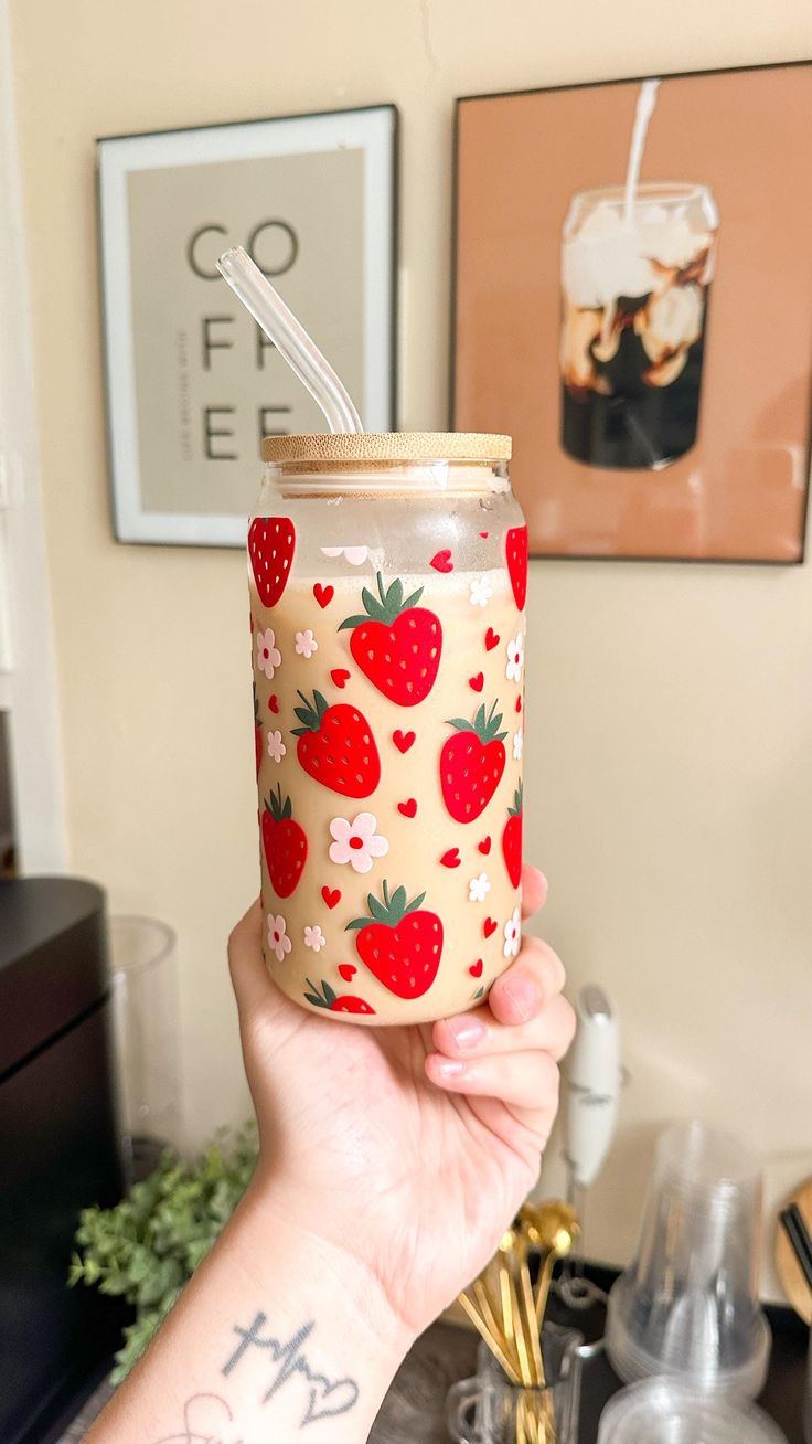 a person holding up a cup with strawberries on it