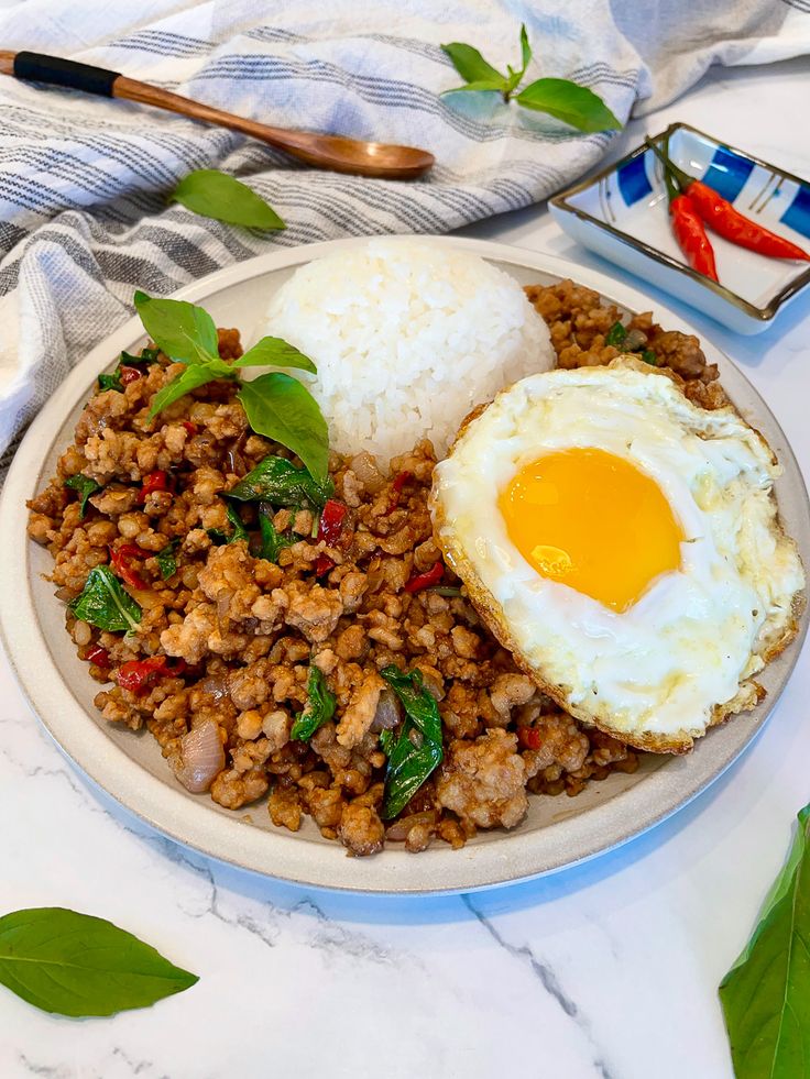 a white plate topped with rice, meat and an egg