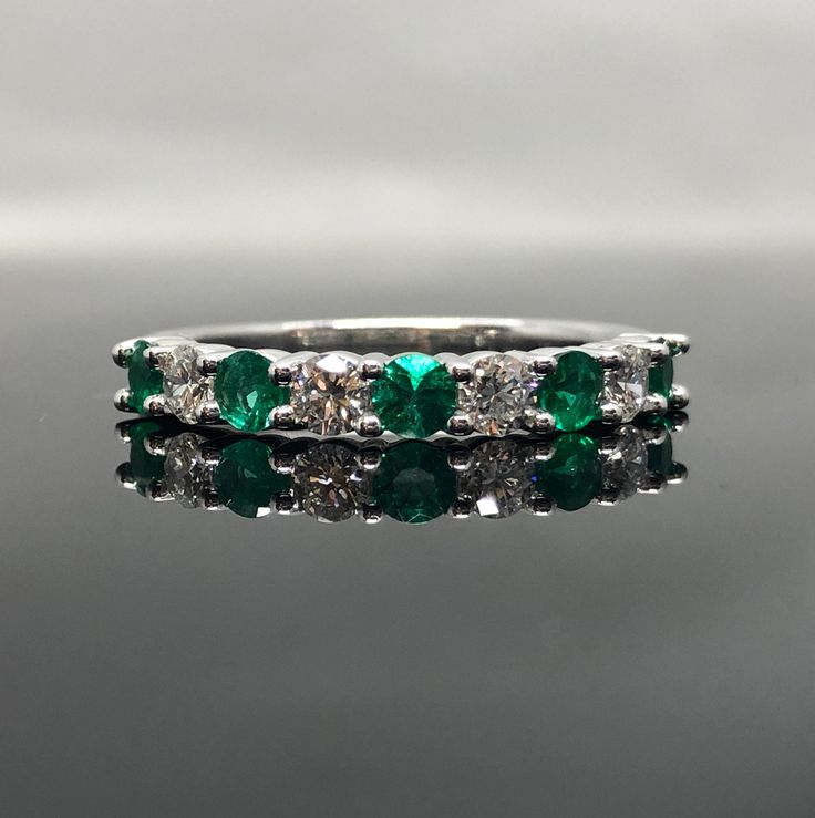 14K White Gold Sapphire and Diamond Band METAL: 14K White Gold TOTAL WEIGHT: 3.3 g DIAMONDS: Natural Round Brilliant Diamonds COLOR: G/H CLARITY: VS2-SI1 TOTAL WEIGHT: 0.40 ct GEMSTONES: Natural Round Brilliant Cut Emeralds FINE QUALITY TOTAL WEIGHT: 0.42 ct SIZE: Ladies 4-8. Please indicate your ring size at checkout. Contact us for all additional sizes. DESCRIPTION: This is a beautiful emerald and diamond band. It has 9 stones total,with diamonds and emeralds alternating. It's classic, prong s Vvs Clarity Diamond Ring For Wedding And May Birthstone, Anniversary Emerald Ring With Brilliant Cut, Classic Half Eternity Ring For May Birthstone, Wedding Round Cut Emerald Ring With Vvs Clarity, Formal Half Eternity Jewelry For May Birthstone, May Birthstone Jewelry With Half Eternity For Formal Occasions, Emerald Diamond Ring For Anniversary With Round Band, Emerald Round Cut Rings For Anniversary, White Gold Emerald Wedding Ring With Diamond Cut