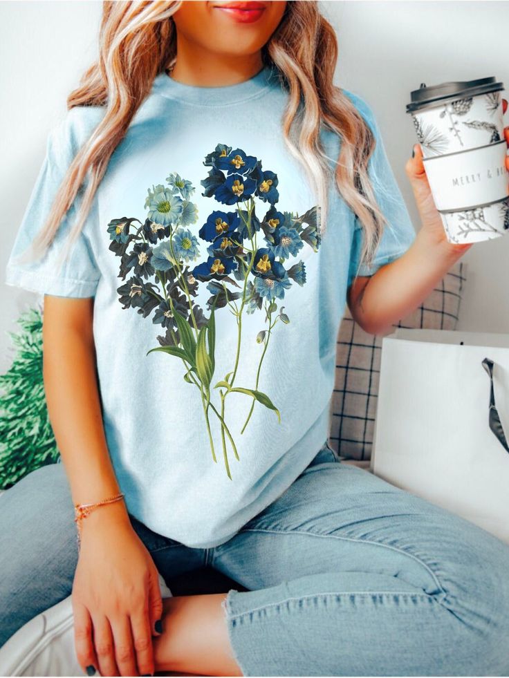 Boho Floral Tee COMFORT COLORS® Vintage Pressed Flowers Blue Wildflowers Dark Cottagecore Shirt Nature Lover Gift Botanical Gardening Shirt  Shop all The June Kind - https://www.etsy.com/ca/shop/TheJuneKind? * Unique Hand drawn Graphics * Women Owned Small Business * Made to Order, especially for You ---------- Please read before placing your order -------------- 1. This apparel is GENDER NEUTRAL / UNISEX. The relaxed fit is flattering for all bodies. 2. Refer SIZE CHART for measurements. Upsize Blue Floral Print Relaxed Fit Tops, Blue Floral Print Top With Relaxed Fit, Light Blue Cotton Shirt With Floral Print, Blue Plant Print Summer Top, Blue Plant Print Top For Summer, Blue Short Sleeve Tops With Plant Print, Blue Short Sleeve Top With Plant Print, Blue Plant Print Crew Neck Top, Blue Tops With Plants Print And Relaxed Fit