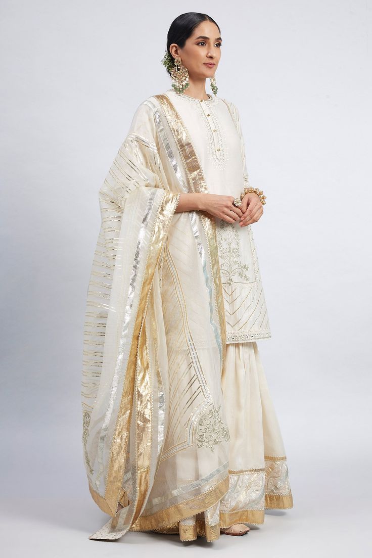 Daisy ivory kurta with gota trims and ghunghroo embellished placket. Comes with gharara and embroidered dupatta.
Component: 3
Embroidered
Neckline: Round
Sleeve Length: Three Quarter
Fabric: Kurta and Garara: Chanderi Silk; Dupatta: Silk Organza
Color: White
Side slits
Concealed placket - Aza Fashions White Anarkali Set With Cutdana For Celebrations, White Sharara With Traditional Drape For Celebration, White Traditional Drape Sharara For Celebrations, Off White Chanderi Palazzo Set With Gota Work, Off White Sharara With Dabka Work For Festivals, Festive White Sharara With Gota Work, White Chinon Palazzo Set For Eid, White Sharara For Festive Celebrations, White Sharara For Festivals And Celebrations