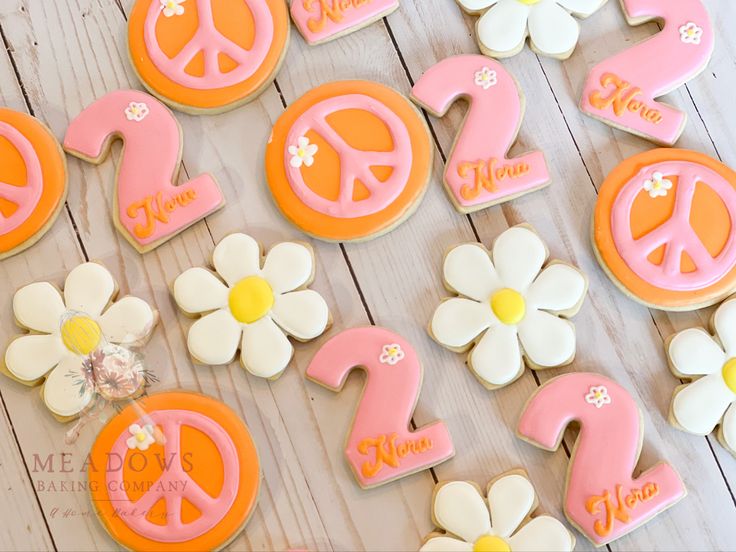 decorated cookies with flowers and peace signs are on a wooden table next to each other