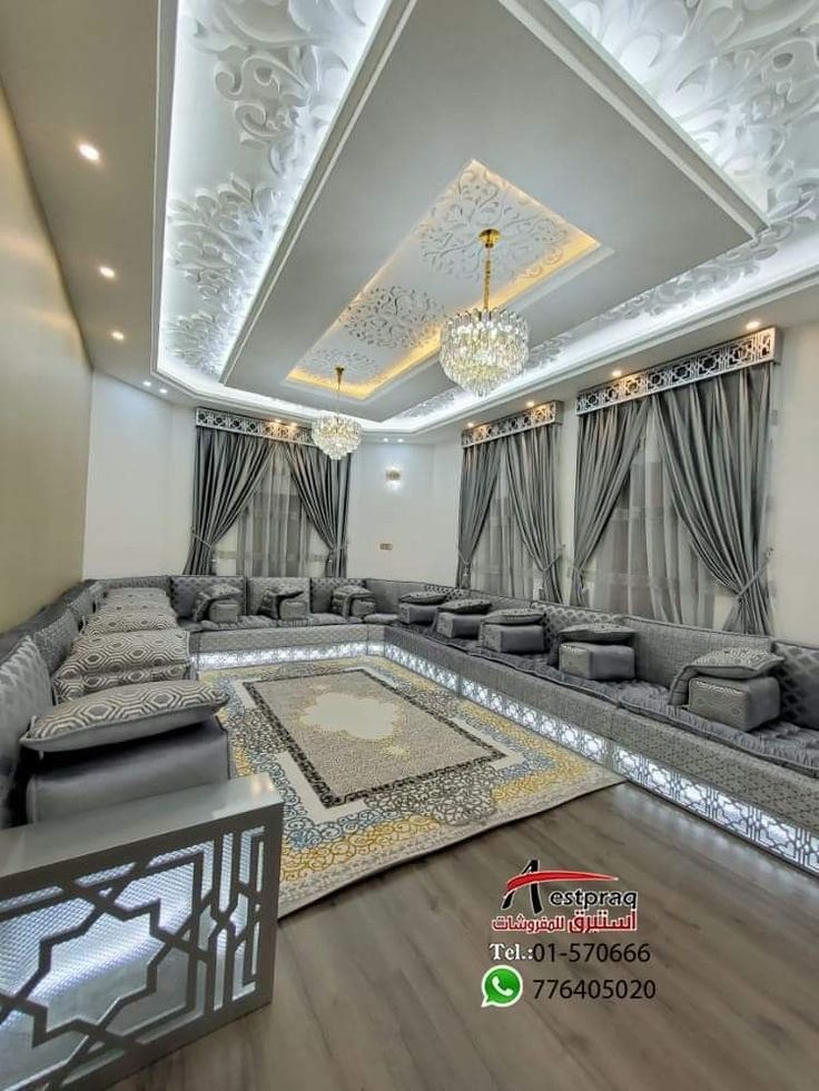 a large living room with couches and chandeliers on the ceiling is decorated in white