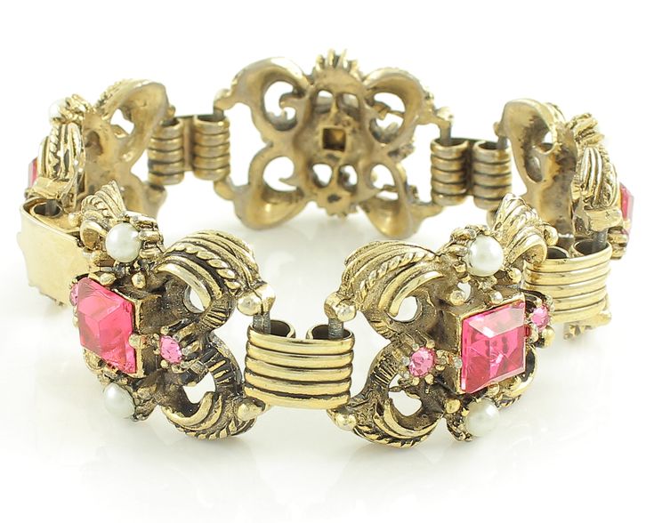 "Vintage Victorian Revival Pink Rhinestone Imitation Pearl Bracelet and Clip On Earring Set. The chunky gold tone bracelet and earrings are set with square and round pink rhinestones and simulated glass pearls. The bracelet links are connected by book link style links. The bracelet is 7 inches long and 15/16 inch wide and the earrings measure approximately 7/8 inch X 1 inch. Finished with a fold over clasp. In Excellent Vintage Condition with no damage noted. ERA: Retro, 1950s METAL/MATERIALS: G Vintage Rhinestone Jewelry For Formal Occasions, Vintage Formal Jewelry With Rhinestones, Vintage Rhinestone Jewelry For Vintage Events, Vintage Jeweled Jewelry For Evening, Vintage Jeweled Bracelets For Party, Antique Jeweled Jewelry For Vintage Events, Retro Jeweled Wedding Jewelry, Vintage Pink Metal Bracelets, Collectible Vintage Jeweled Jewelry