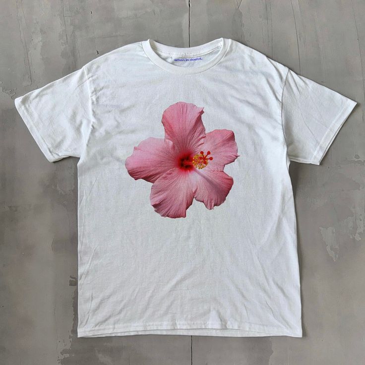 Hibiscus Classic Unisex Tee Hibiscus Classic Unisex Tee, Heavy Cotton Graphic T-Shirt, Iconic Slogan Print - 100% cotton - Classic Unisex fit - Runs true to size (refer to size chart) - Tear-away label - Y2K Vintage Streetwear Trending Fashion - Environmentally sustainable made-to-order system Please refer to the size chart in the listing photos for more sizing details. Don't forget to tag us in any photos or videos :) White Hibiscus Print T-shirt For Spring, Cotton Floral Print Tops For Streetwear, White Graphic Print Hawaiian Shirt, Pink Hawaiian Shirt With Graphic Print, Hawaiian Cotton Tops With Screen Print, Pink Hibiscus Print T-shirt For Summer, Cotton Hawaiian Streetwear Tops, Tropical Cotton Tops With Graphic Print, Hawaiian Cotton Tops For Streetwear