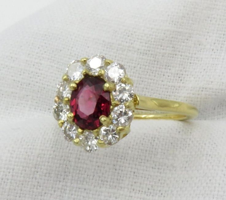 Sale.  Originally $2,975.00 A very pretty oval mixed cut Red Spinel surrounded by diamonds.  This spinel has a gorgeous red color and the diamonds surrounding the ring add a lovely sparkle and contrast.  A perfect non-traditional engagement ring. Overview: The ring is prong set with a oval mixed cut Red Spinel.  Prong set around the center stone are ten (10) round brilliant cut diamonds.  The top of the ring measures 12.0mm x 10.7mm x 6.1mm. The shank measures 1.40mm wide and 1.1mm thick. Size 6 Dazzling Oval Ruby Ring, Red Diamond Cluster Ring With Halo Setting, Dazzling Oval Ruby Ring With Diamonds, Red Oval Cluster Ring With Rose Cut Diamonds, Classic Red Oval Halo Ring, Oval Red Cluster Ring With Center Stone, Oval Ruby Cluster Ring With Rose Cut Diamonds, Oval Ruby Halo Ring With Brilliant Cut, Classic Red Oval Cluster Ring