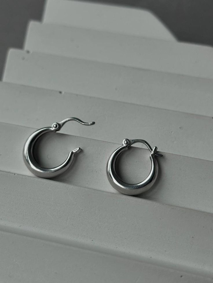 Elegant and stylish, the 925 Chunky Silver Hoops are an expression of contemporary design and classic sophistication. Crafted from high-quality sterling silver (925), these earrings impress with their refinement and tastefulness. The Chunky Silver Hoops feature large yet lightweight rings, giving them a distinctive and modern look. Their design seamlessly complements various clothing styles, adding uniqueness and charm to any outfit. ▶Product weight(2 earings): 2.91 g. ▶▶Weight silver(925) 2.91 g. The convenience and safety of the secure closure ensure comfort during wear, while simultaneously drawing attention with their sophistication. These earrings make an excellent addition to both everyday and special occasion attire, allowing you to express your unique style and sophistication. Choo Minimalist Sterling Silver Tarnish Resistant Earrings, Trendy Silver Jewelry With Simple Design, Minimalist Tarnish Resistant Sterling Silver Earrings, Minimalist Tarnish-resistant Sterling Silver Earrings, Trendy Sterling Silver Drop Cartilage Earrings, Trendy Sterling Silver Cartilage Earrings As A Gift, Elegant Silver Hoop Earrings As A Gift For Her, Modern Cartilage Earrings With Ear Wire As Gift, Trendy Silver Hoop Cartilage Earrings