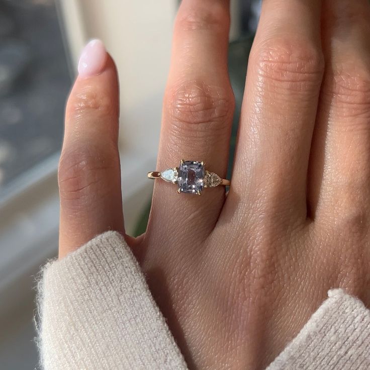 a woman's hand with a ring on it and a diamond in the middle