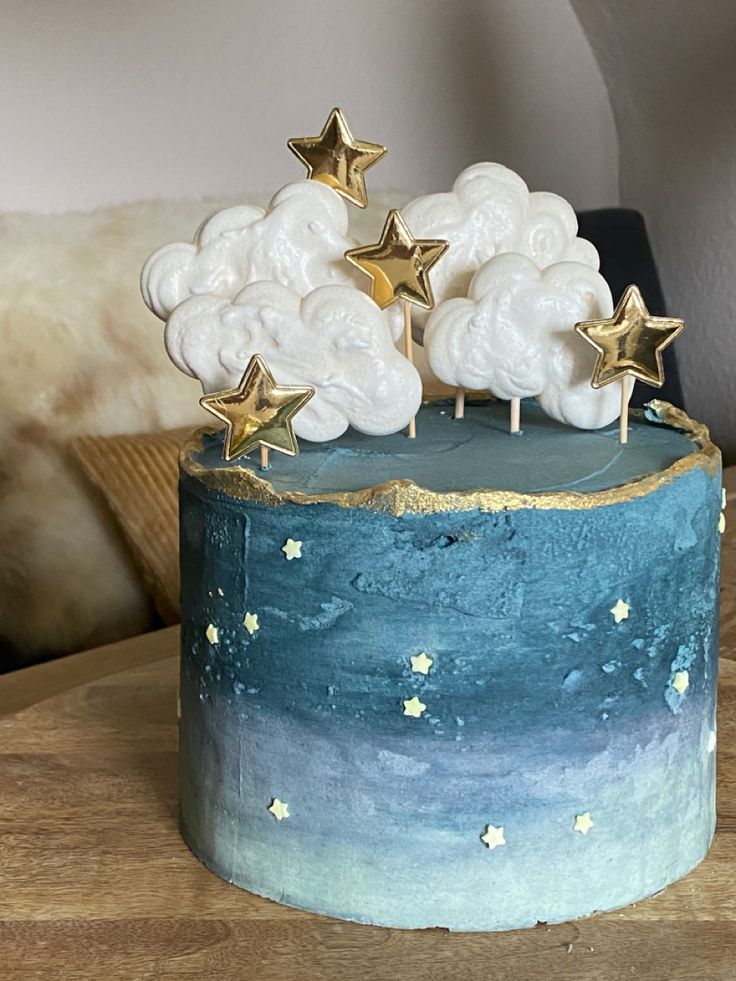 a cake decorated with stars and clouds on a table