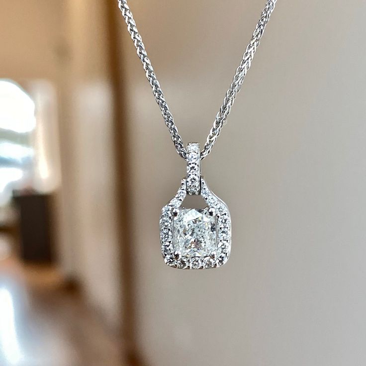 One (1) 14KT white gold cushion cut diamond halo pendant 88/100ctw. Prong set in the center with one cushion cut diamond 72/100CT of (G) color (I1) clarity GIA Certified. Diamond halo and bail is prong set around center with (38) round brilliant cut diamonds 16/100CTW of fine (G-H) color and (SI) clarity. White Diamond Necklace With Halo Design, White Diamond Necklace With Halo Setting, Diamond Necklace With Halo Setting, White Platinum Jewelry With Halo Design, Elegant White Radiant Cut Jewelry, Dazzling Diamond Square Pendant Jewelry, White Gold Square Pendant Diamond Necklace, Diamond White Diamond Necklace With Halo Design, White Gold Necklace With Cushion Cut Halo Setting