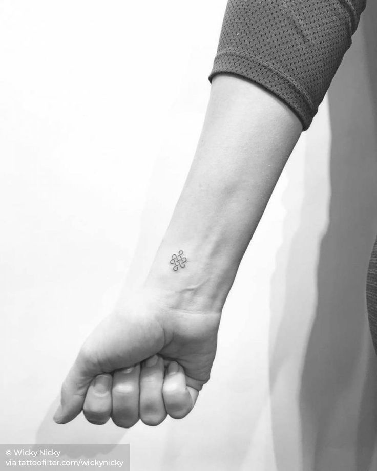 a person with a small tattoo on their wrist holding the hand of another person's arm